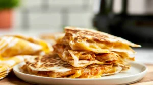 Delicious air fryer chicken quesadillas served on a plate with toppings